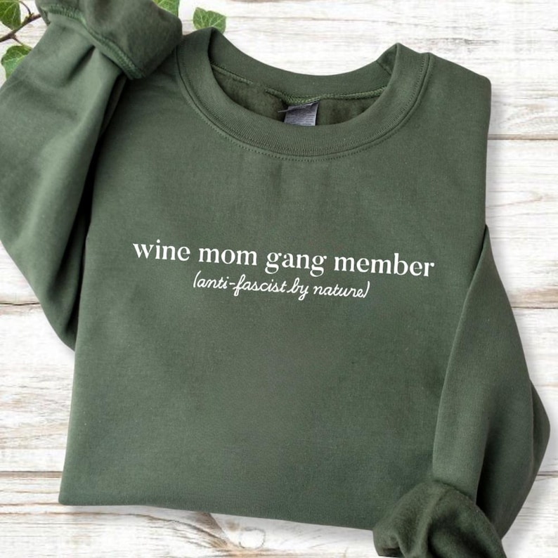 A green sweatshirt with white text printed on it.