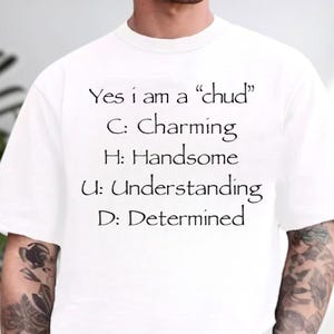 May include: White t-shirt with black text. The text reads "Yes i am a 'chud'" followed by the words "Charming, Handsome, Understanding, Determined", each starting with a letter from the word "chud".