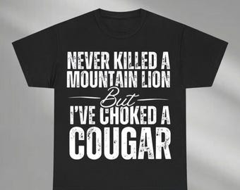 May include: Black t-shirt with white text that reads "Never killed a mountain lion but I've choked a cougar".