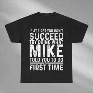 May include: Black t-shirt with white text that reads: "IF AT FIRST YOU DON'T SUCCEED TRY DOING WHAT MIKE TOLD YOU TO DO THE FIRST TIME."