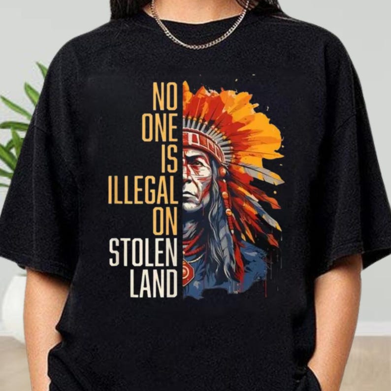 a woman wearing an indian headdress with the words no one is illegal on