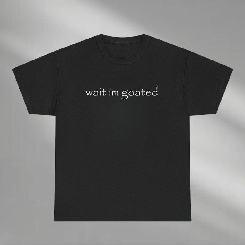 a black t - shirt that says wait i'm goated