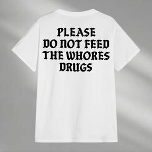 a t - shirt that says please do not feed the whores drugs