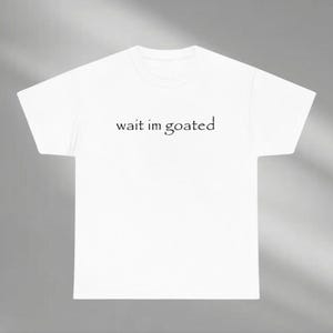 a white t - shirt that says wait im goated