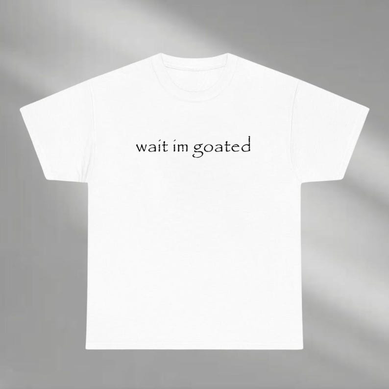 a white t - shirt that says wait im goated