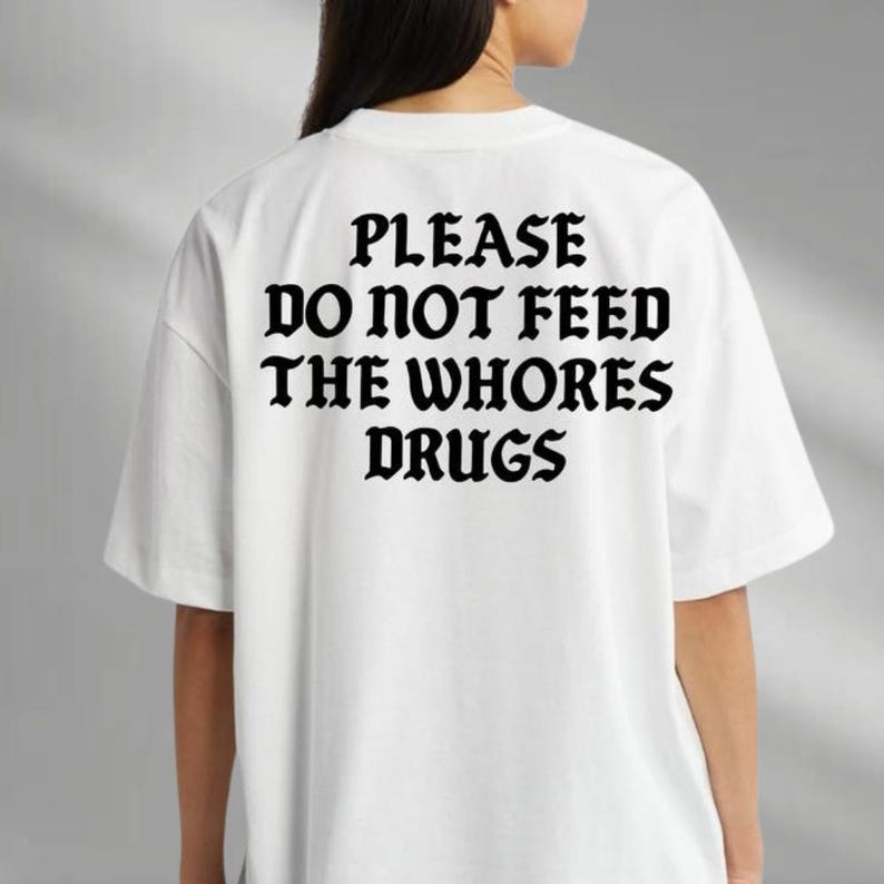 a woman wearing a t - shirt that says please do not feed the whores