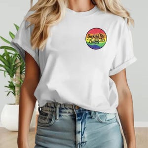 a woman wearing a white t - shirt with a rainbow logo