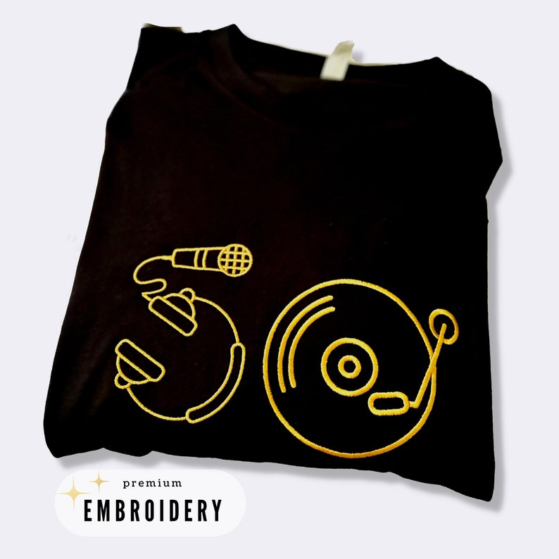 May include: Black t-shirt with gold embroidery of a microphone, a record, and a turntable. The text "premium embroidery" is at the bottom of the shirt.
