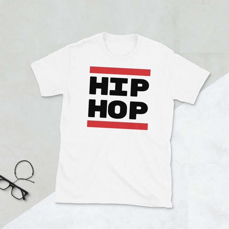 May include: White t-shirt featuring the words "HIP HOP" in bold black text, set between two red horizontal lines. The shirt has a crew neck and short sleeves.