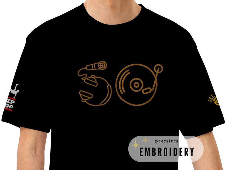 May include: Black t-shirt with a gold outline of a microphone and a record player. The text "premium embroidery" is in the bottom right corner.