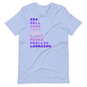 K&ouml;nnte beinhalten: Hellblaues T-Shirt mit einem vertikalen Farbverlauf aus lila und rosa Text, der "IDA BELL ZORA MAYA TONI ALICE NIKKI PHILLIS LORRAINE" lautet