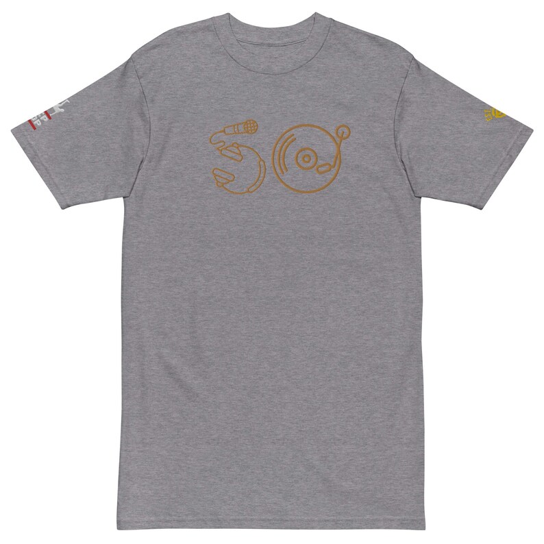 May include: A heather grey t-shirt with a brown outline of a microphone and a record player on the front. The design is stylized to look like the letters "SO".