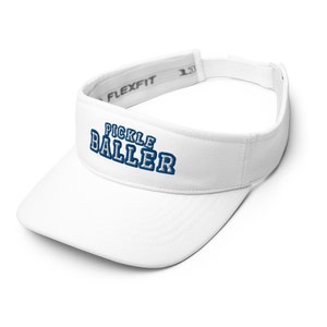 K&ouml;nnte beinhalten: Wei&szlig;er Visier mit einem blauen gestickten Logo, auf dem vorne "Pickle Baller" steht. Der Visier hat ein verstellbares schwarzes Band mit dem aufgedruckten Wort "Flexfit".