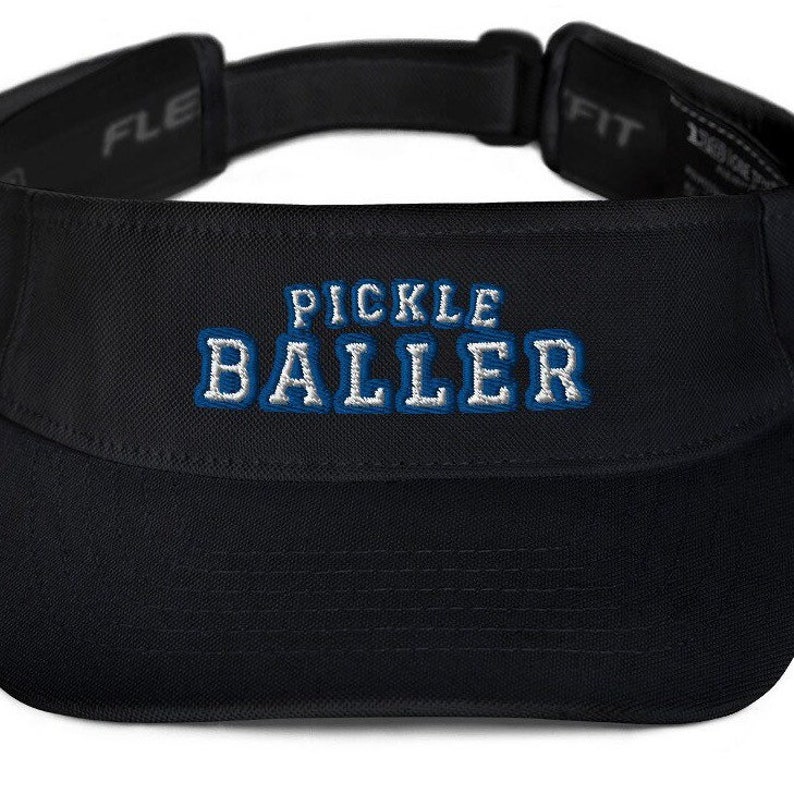K&ouml;nnte beinhalten: Schwarzer Visier mit einem blauen und wei&szlig;en gestickten Logo, auf dem "Pickle Baller" steht.