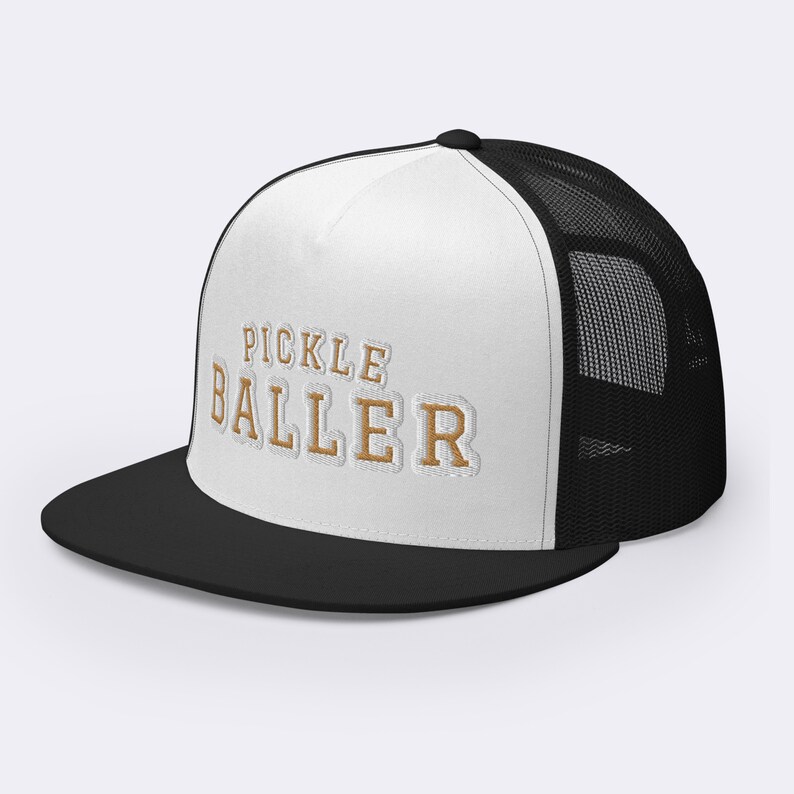 May include: White and black trucker hat with a gold embroidered design that says "Pickle Baller".