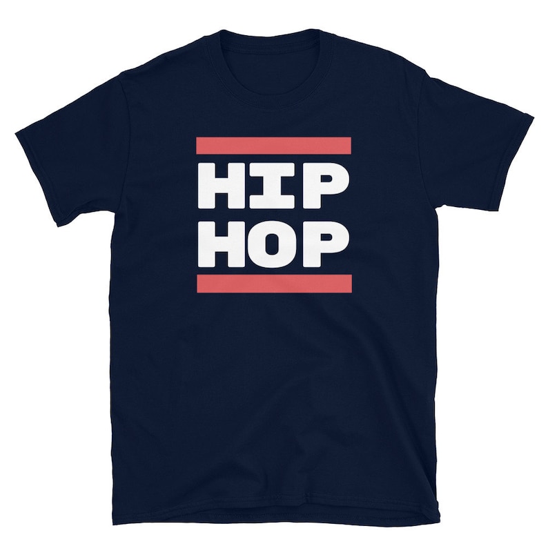 May include: A navy blue t-shirt featuring the text "HIP HOP" in bold white capital letters, set between two coral-coloured lines. The shirt has a crew neck and short sleeves.