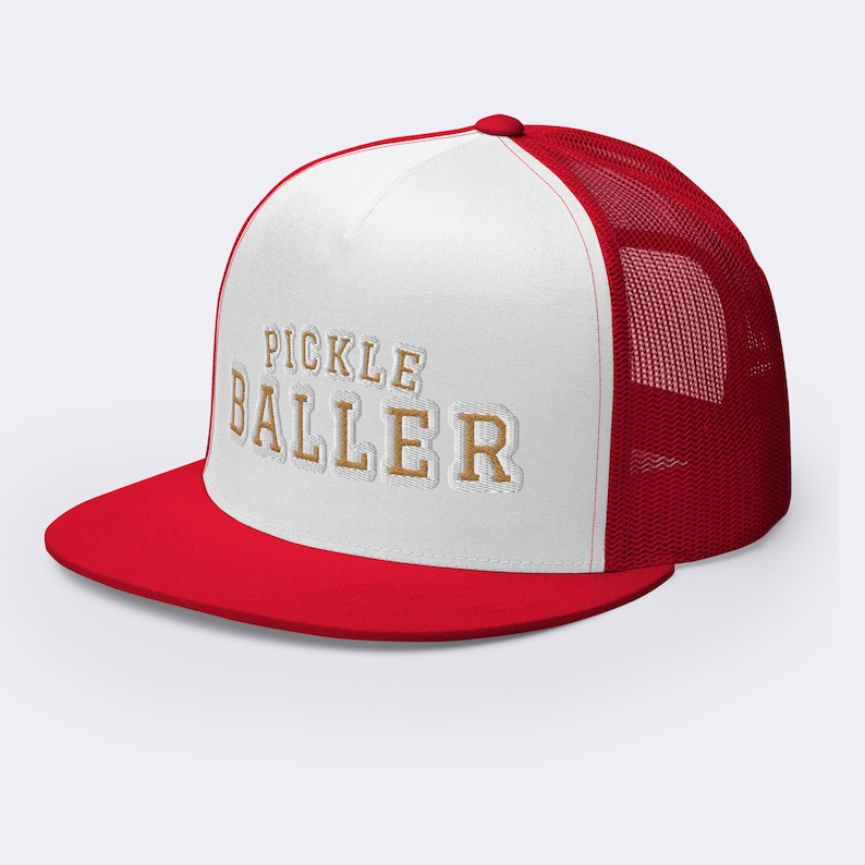 May include: White and red trucker hat with a gold embroidered design that says "Pickle Baller".