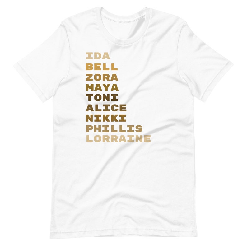 K&ouml;nnte beinhalten: Wei&szlig;es T-Shirt mit einer vertikalen Liste von Namen in brauner und goldener Schrift: Ida Bell, Zora, Maya, Toni, Alice, Nikki, Phillis, Lorraine.