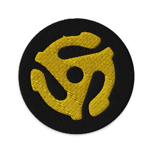 May include: A yellow vinyl record symbol embroidered on a black circular patch.