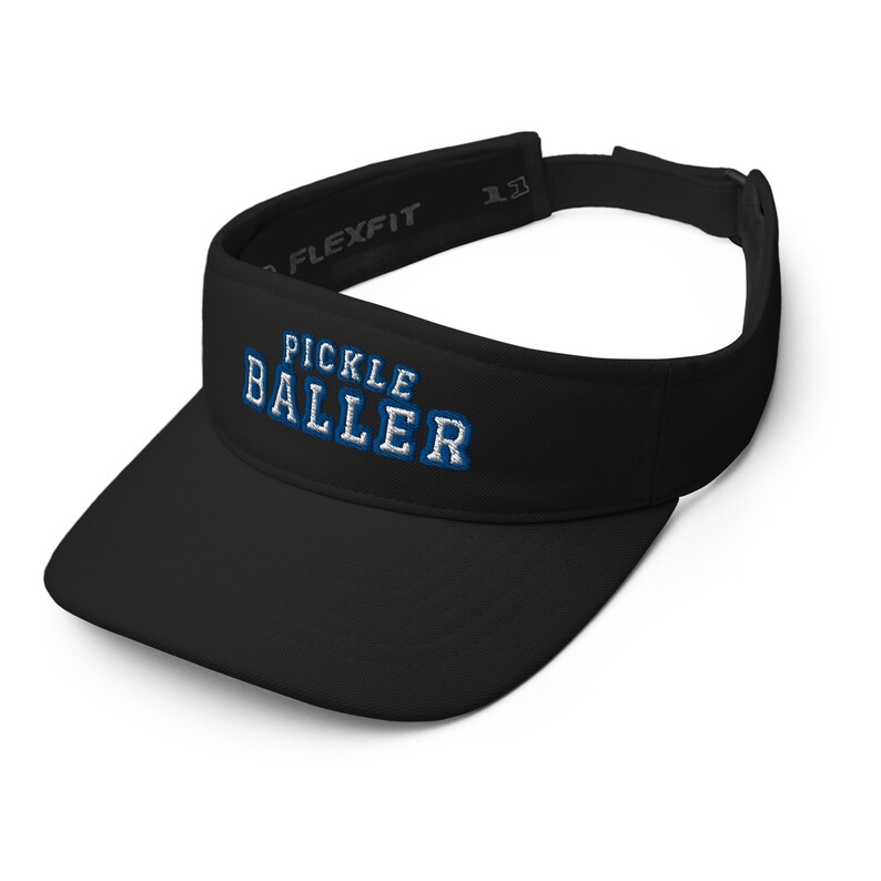 K&ouml;nnte beinhalten: Schwarzer Visier mit dem Text "Pickle Baller" in blauen und wei&szlig;en Buchstaben.