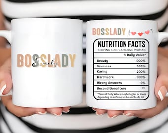 Pode incluir: Caneca de cerâmica branca com o texto "BOSSLADY Emily" em cores pastel. O outro lado apresenta um rótulo de "Informação Nutricional" com valores para qualidades como beleza e trabalho duro. Um presente divertido e motivacional.