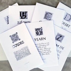 May include: A set of eight cards with black and white illustrations and text. Each card features a different letter of the alphabet and a word. The words are: Balance, Doubt, Explore, Yearn, and  'I'm in'.