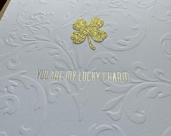 You are my lucky charm + sparkle shamrock in gold foil over embossed flourish letterpress card with hot foiled clover love note