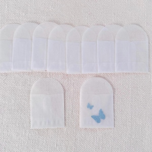 May include: Ten white paper envelopes with a scalloped top edge. Two of the envelopes have a blue butterfly design.