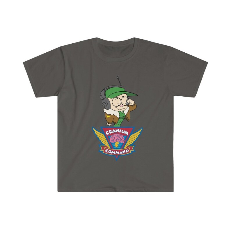 May include: Dark grey t-shirt with a cartoon character wearing a green cap, aviator jacket, and headset. The shirt displays a colourful emblem with the words "Cranium Command" and a brain graphic with wings.