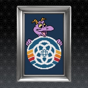 May include: Cross-stitch art framed in silver. The artwork features a purple dragon character holding a blue and white wheel with orange, yellow, and red stripes. The background is a dark blue color.