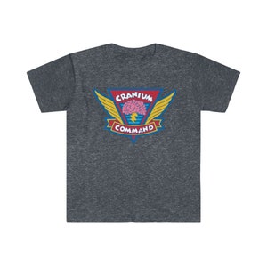 以下が含まれることがあります： 鮮やかなグラフィックが特徴のダークヘザーグレーのTシャツ。ピンクの脳、黄色の翼、赤で「CRANIUM COMMAND」、黄色で「COMMAND」の文字が描かれています。青い稲妻も描かれています。