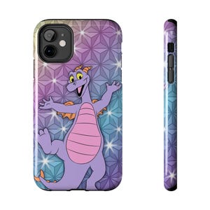 May include: A phone case with a cartoon purple dragon design, orange wings, and a pink belly, set against a geometric background of blue, purple, and white. The case has a black camera cutout and a matching side design.