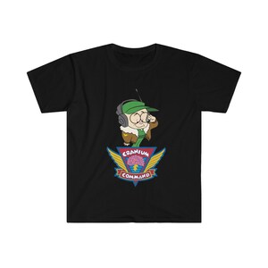May include: Black t-shirt with a cartoon character wearing a green cap and headset, holding a microphone. Below the character is a colourful emblem with the words "Cranium Command" and a brain graphic.