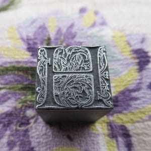 Bloc d&#39;impression typographique antique ornement décoratif initial H en métal