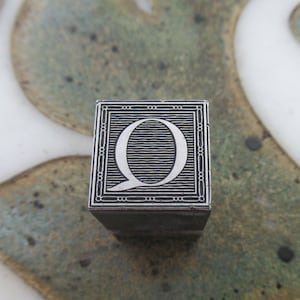 Bloc d&#39;impression typographique en métal antique avec ornement décoratif Caslon Initial Q
