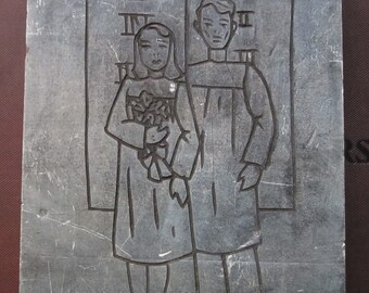 May include: A black and white image of a couple standing in front of two stone tablets. The man is on the right and the woman is on the left. The woman is holding a bouquet of flowers. The tablets have Roman numerals on them.