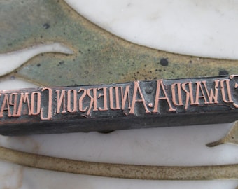 May include: A close-up of a metal printing block with the text "F. EDWARD A. ANDERSON COMPANY" in copper lettering.