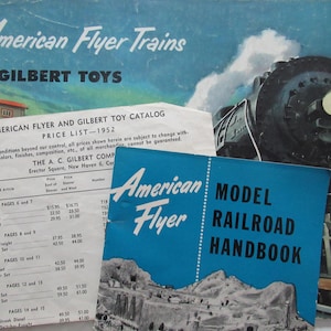 May include: A blue and white American Flyer Model Railroad Handbook booklet with the text "American Flyer Model Railroad Handbook" on the cover. The booklet is lying on top of a price list for American Flyer and Gilbert toy catalogs from 1952.