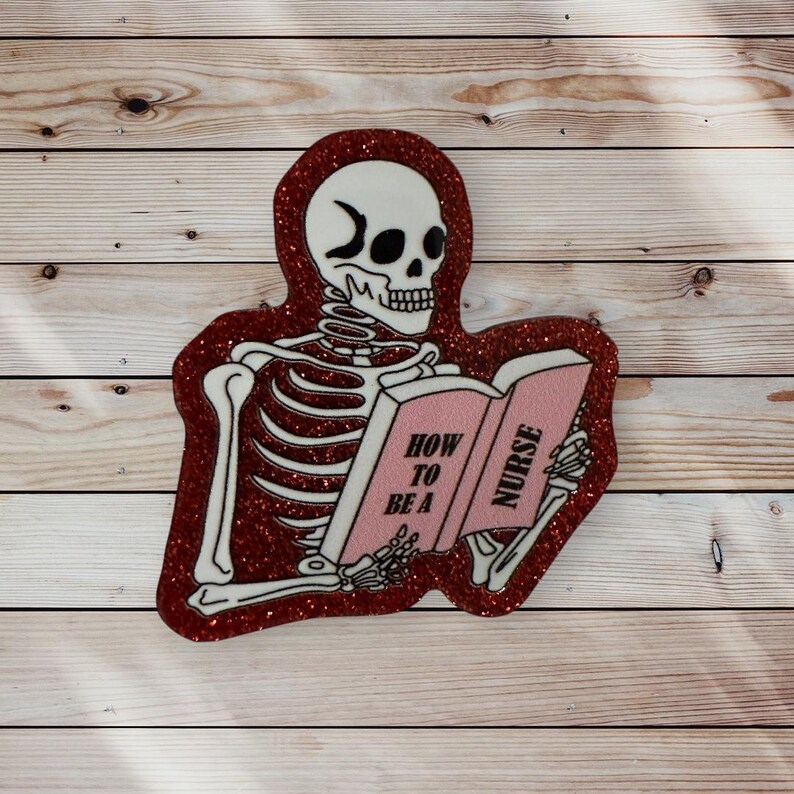 May include: A red glitter sticker with a skeleton reading a book that says "How to be a Nurse".