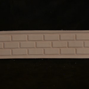 May include: A close-up of a light brown leather strip with a brick pattern embossed into the surface.