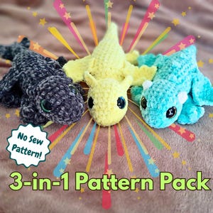 May include: Three crocheted dragon toys in black, yellow, and teal. Each dragon has large, round eyes and small wings. The image includes text that reads "No Sew Pattern!" and "3-in-1 Pattern Pack".