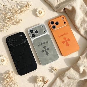 May include: Three phone cases in black, silver, and orange. Each case features a cross design and the word "FOREVER". The black case has a textured surface with multiple crosses. The silver and orange cases have a smooth finish.