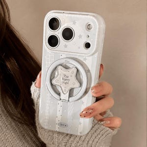 May include: A light blue smartphone case featuring a pattern of white stars and vertical stripes. The case includes a circular ring holder with a star-shaped center piece displaying the text The Starry Night and the brand name Bonne at the bottom.