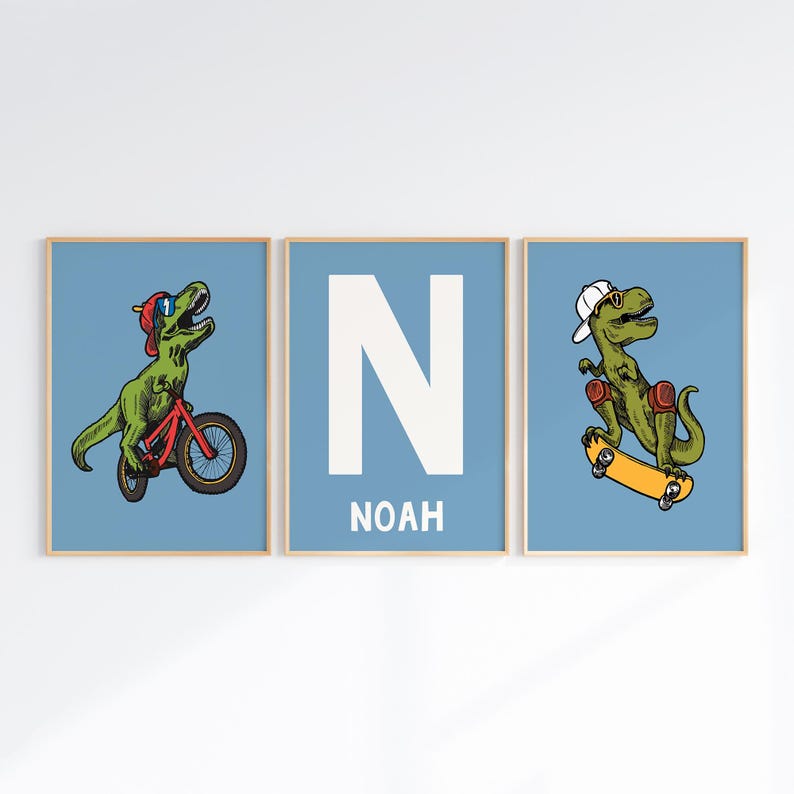 May include: Three blue and white prints with a dinosaur riding a bike, a dinosaur skateboarding, and a large white letter N with the name Noah below it.