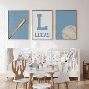 K&ouml;nnte beinhalten: Drei blaue und wei&szlig;e Kinderzimmerbilder zum Thema Baseball. Das erste Bild zeigt einen Baseballschl&auml;ger, das zweite Bild zeigt einen gro&szlig;en Buchstaben L und den Namen Lucas, und das dritte Bild zeigt einen Baseball.