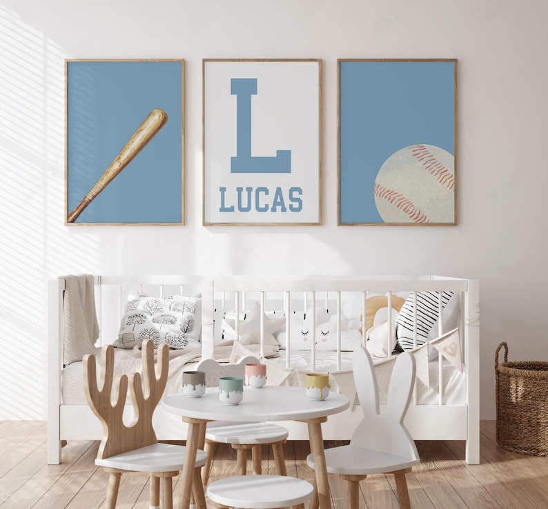 K&ouml;nnte beinhalten: Drei blaue und wei&szlig;e Kinderzimmerbilder zum Thema Baseball. Das erste Bild zeigt einen Baseballschl&auml;ger, das zweite Bild zeigt einen gro&szlig;en Buchstaben L und den Namen Lucas, und das dritte Bild zeigt einen Baseball.
