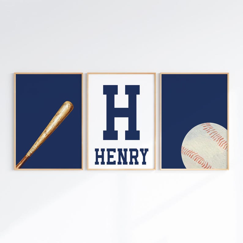 K&ouml;nnte beinhalten: Drei gerahmte Drucke mit einem marineblauen Hintergrund. Der linke Druck zeigt einen h&ouml;lzernen Baseballschl&auml;ger. Der mittlere Druck zeigt einen gro&szlig;en marineblauen Buchstaben H und den Namen HENRY in marineblauem Text. Der rechte Druck zeigt einen wei&szlig;en Baseball mit roten N&auml;hten.