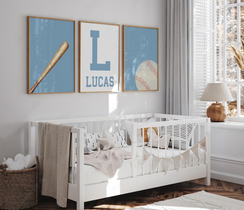 K&ouml;nnte beinhalten: Drei blaue und wei&szlig;e gerahmte Drucke mit Baseball-Motiven. Die Drucke zeigen einen Baseballschl&auml;ger, den Buchstaben L und einen Baseball. Der mittlere Druck tr&auml;gt den Namen Lucas unter dem Buchstaben L.