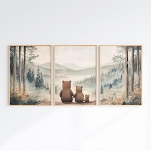 May include: A triptych of framed watercolour prints. The central print shows a bear family, two larger bears and a smaller one, looking at a misty mountain landscape. The side prints depict forest scenes with tall trees.