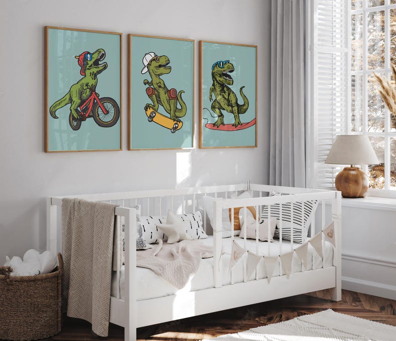 Puede incluir: Tres ilustraciones enmarcadas de dinosaurios verdes sobre un fondo azul claro. Los dinosaurios van en bicicleta, patineta y surf. Los marcos son de madera con un acabado marr&oacute;n claro.